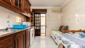 A compact kitchen with wooden cabinets, a washing machine, and a sink.