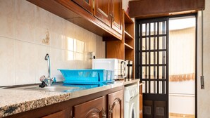 A kitchen with wooden cabinets, a sink, a dishwasher, and a blue dish rack.