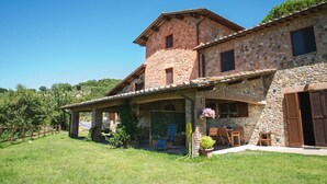 A stone house with a covered patio and outdoor seating area.