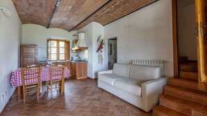 Un amplio salón con una mesa de comedor, un sofá y una cocina al fondo.