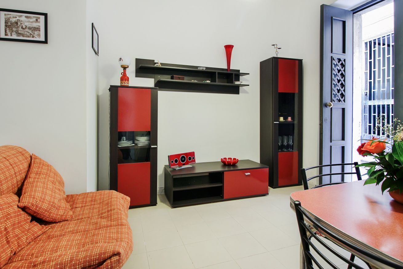 Un soggiorno con un divano, un tavolino da caffè, un mobile TV e un tavolo da pranzo.