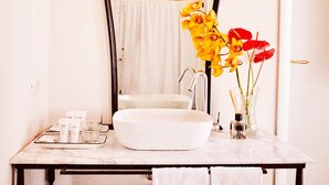 Une salle de bain avec un lavabo blanc, un miroir et deux appliques murales.