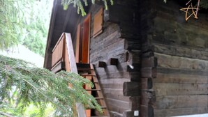 Una cabaña rústica de madera con una escalera de madera que lleva a una puerta.