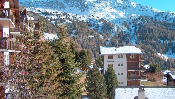A mountain resort with snow-covered peaks, wooden buildings, and pine trees. - Outside : Living on the 3rd floor of an apartment house, in Chandolin, for 2-4 persons, balcony with (Chandolin)