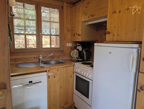 A compact kitchen with wooden cabinets, a Bosch dishwasher, a stove, and a refrigerator. - Outside: individual chalet on 3 floors for max. 5 people in the center of the old village with direc (St-Luc)