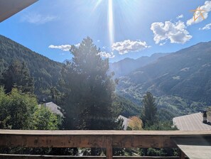 A mountainous landscape with a wooden deck overlooking a valley.