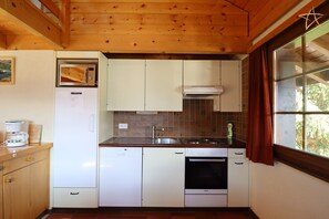 A compact kitchen with white cabinets, a microwave, a coffee maker, and a dishwasher.
