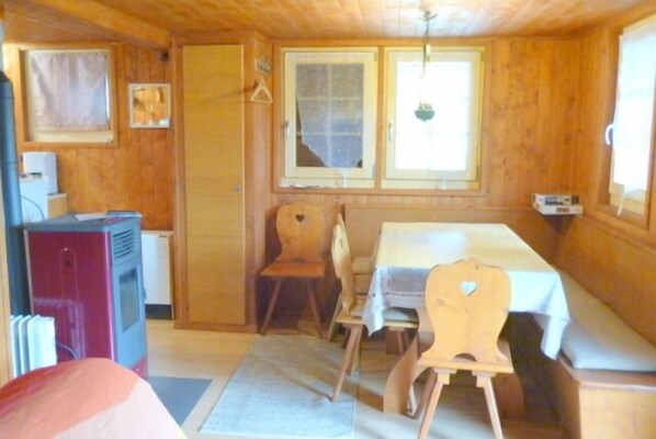 Eine Holzhütte mit Essbereich, einer kleinen Küche und einem Fenster mit Blick.
