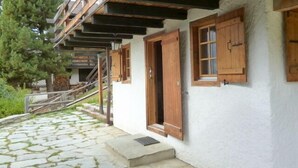 Un edificio con ingresso in pietra, persiane in legno e una scalinata che conduce a un pontile in legno.