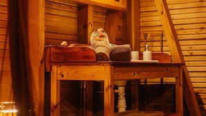 A wooden cabin interior with a wooden bench, a mirror, and a small table with towels and toiletries. - Family fun... The star cabin (Deshaies)