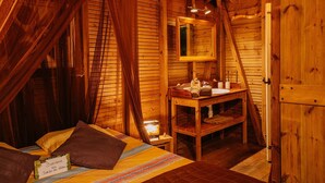 A wooden room with a bed, a bedside table, a mirror, and a door. - Family fun... The star cabin (Deshaies)