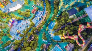 An aerial view of a water park with multiple pools, slides, and a large wave pool. - Radisson Suzhou (Suzhou)