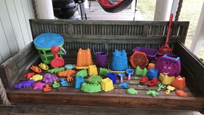 Eine Holzbank mit bunten Plastikspielzeugen darauf.