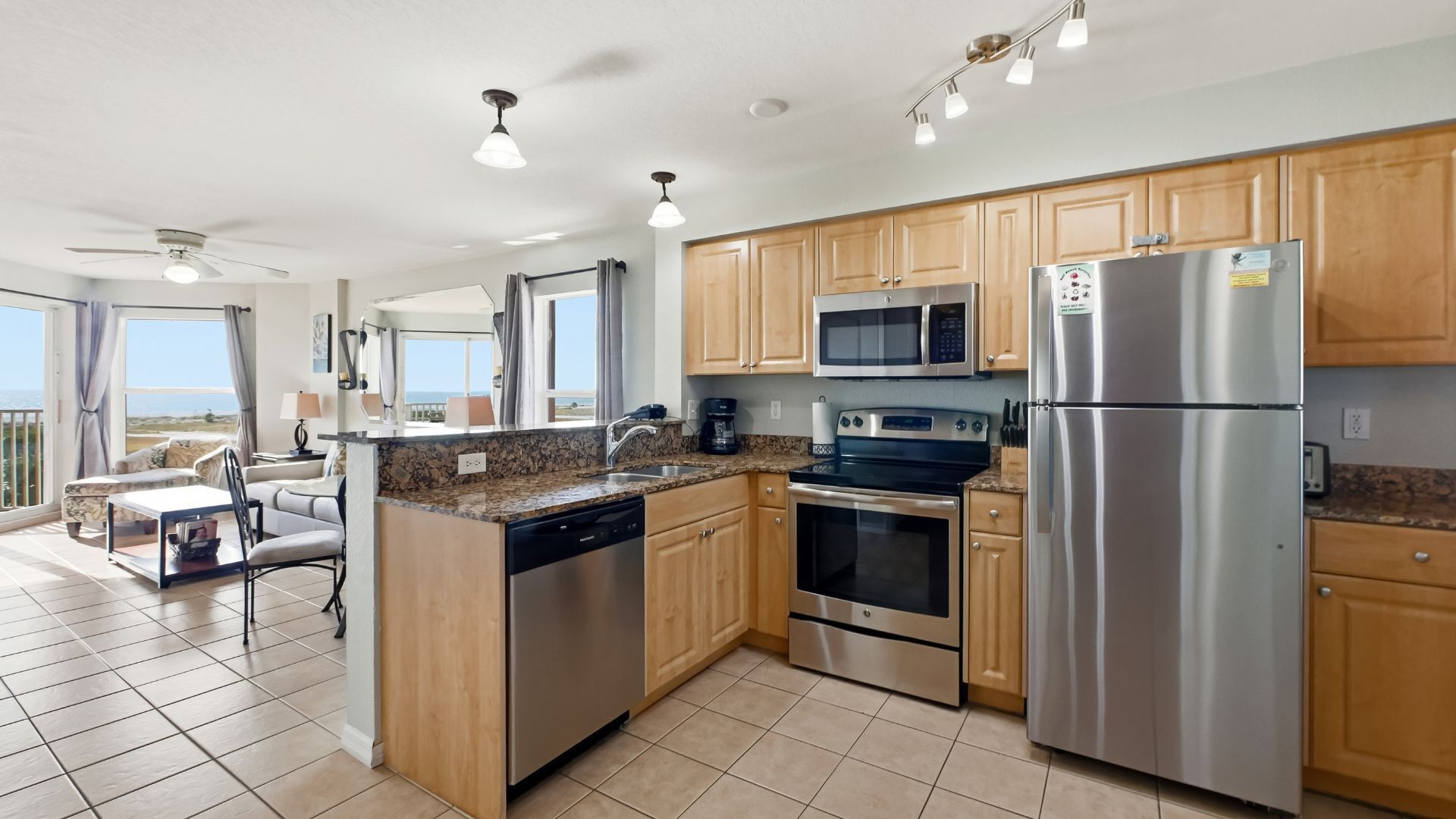 A modern kitchen with wooden cabinets, stainless steel appliances, and a large island.