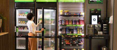 Uma seção de mantimentos com prateleiras refrigeradas identificadas como 'Bebidas', 'Fresh' e 'Snacks'.