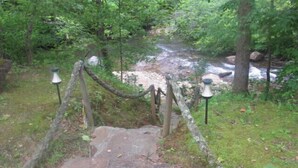Un sendero de piedra que serpentea por un bosque con un arroyo.