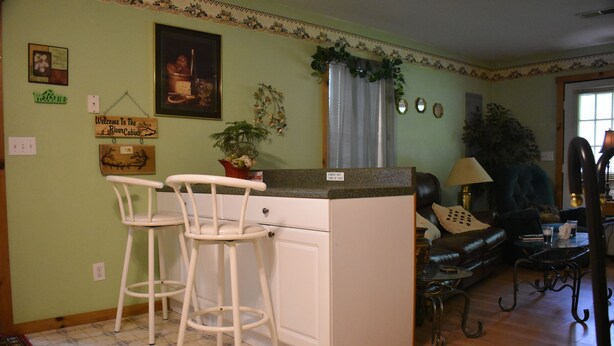 Una cocina con barra, una mesa de comedor y un sofá en la sala de estar.