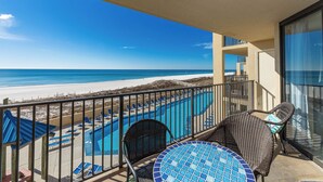 A balcony with a view of a beach and a pool area. - Coastal 2BR Gulf Front Condo - Phoenix V 213 (Orange Beach)