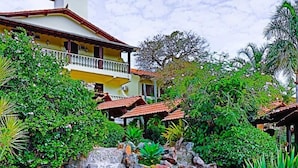 A house with a waterfall, lush greenery, and a pool. - Hotel Dom Otto (Vespasiano)