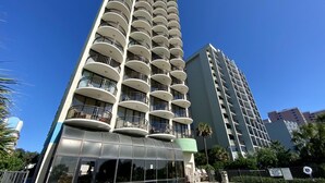 A high-rise hotel with multiple balconies, a swimming pool, and a covered area with chairs. - Meridian Plaza by Palmetto Vacations (Myrtle Beach)