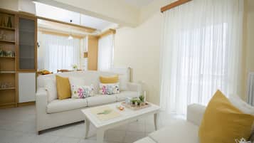 Apartamento conforto, vista para o mar | Sala de estar | TV de tela plana