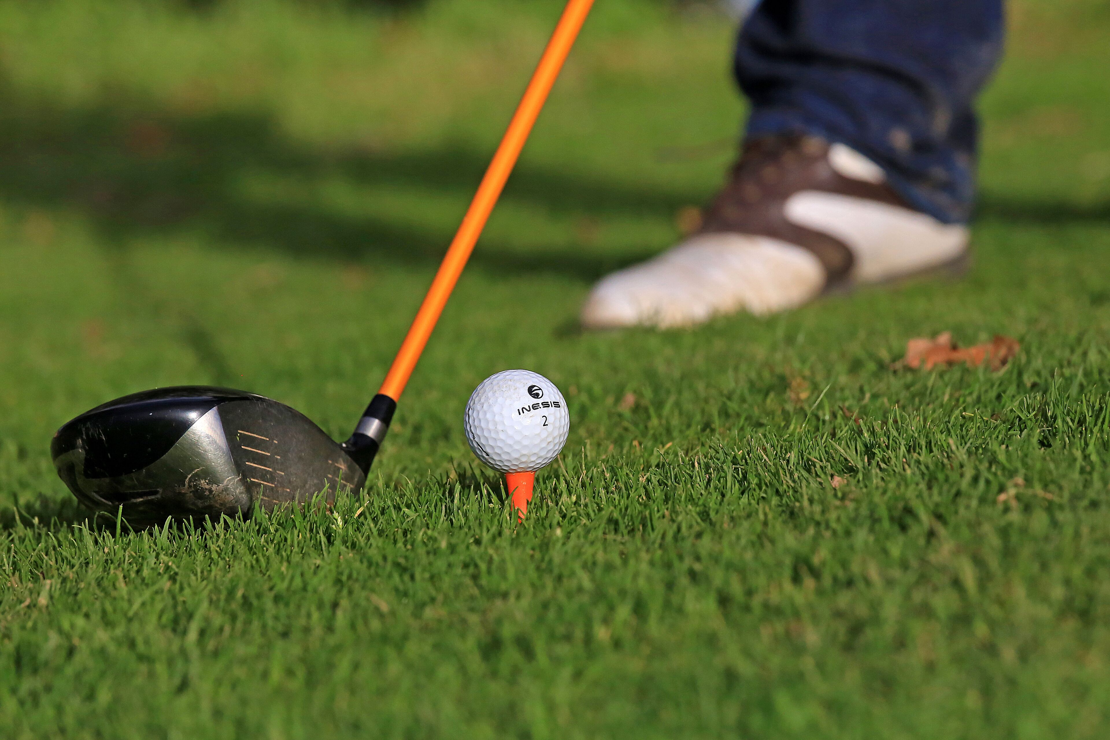 Una pelota de golf sobre un elevador en un campo de césped.