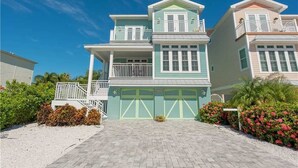 A two-story house with a front garage, a balcony on the second floor, and a small porch.