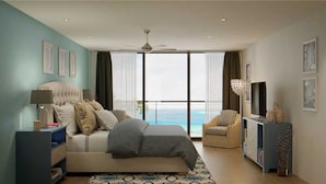 A modern bedroom with a bed, a television, a chair, and a view of the ocean. - Deluxe King Gulf View Rm 104 Apartment 1 (Holmes Beach)