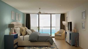 A modern bedroom with a bed, a television, a chair, and a view of the ocean.