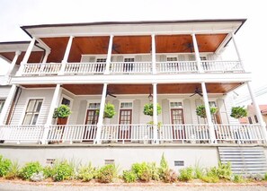 A two-story building with a balcony on each floor, white railings, and potted plants. - 154 ABC Spring Street - 7 BR / 5 BA Holiday home 7 (Charleston)