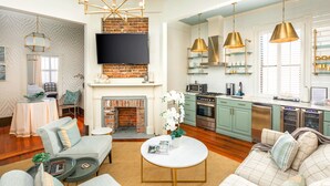 A spacious living room with a fireplace, a television, and a kitchen with modern appliances. - 154 ABC Spring Street - 7 BR / 5 BA Holiday home 7 (Charleston)
