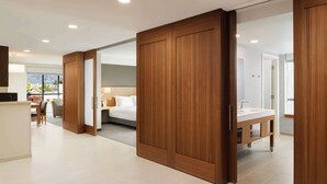 Une chambre d’hôtel moderne avec une armoire en bois, un lit, un bureau et une vue sur les montagnes.