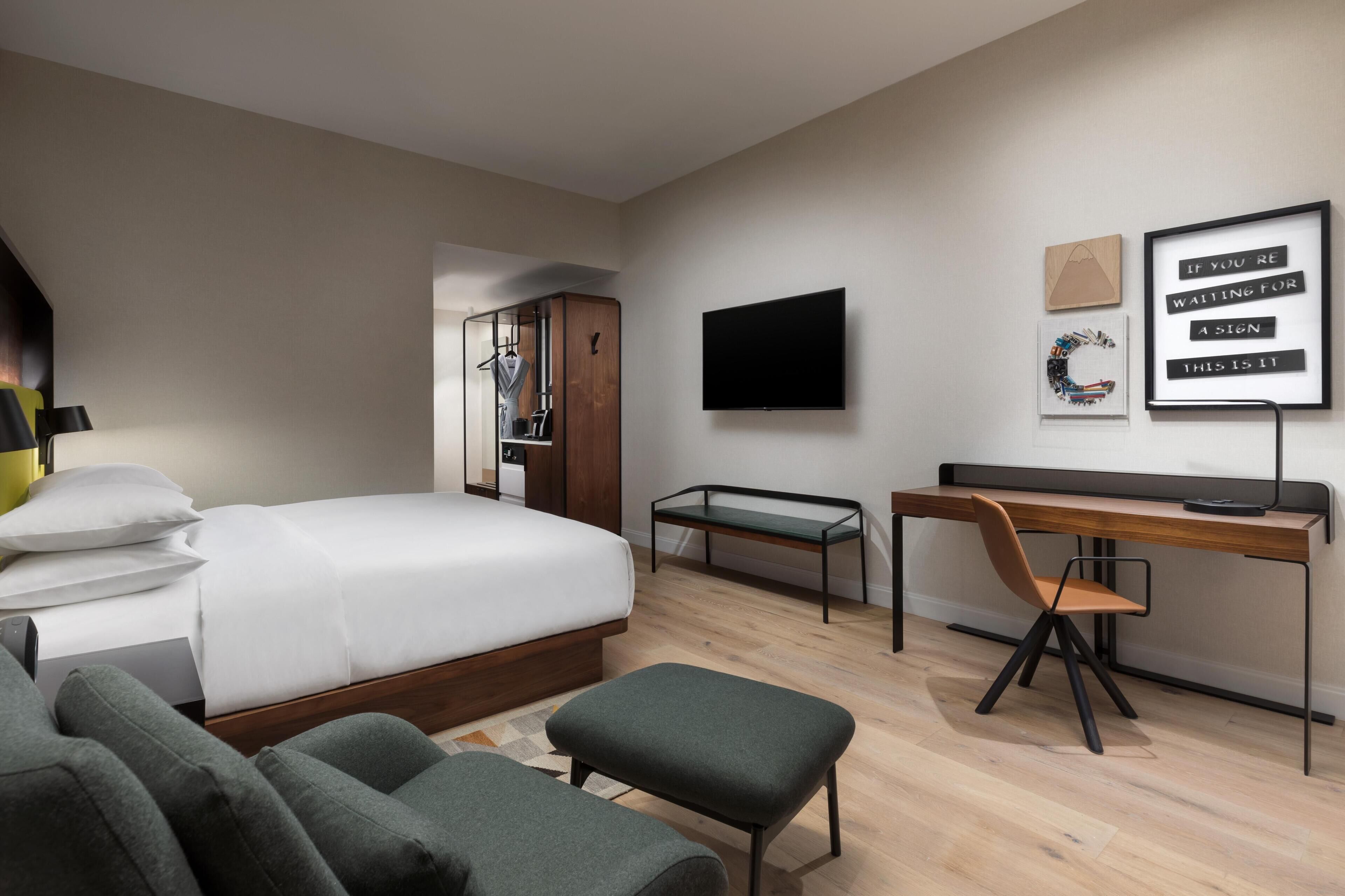 Una habitación de hotel moderna con cama, escritorio y zona de estar.
