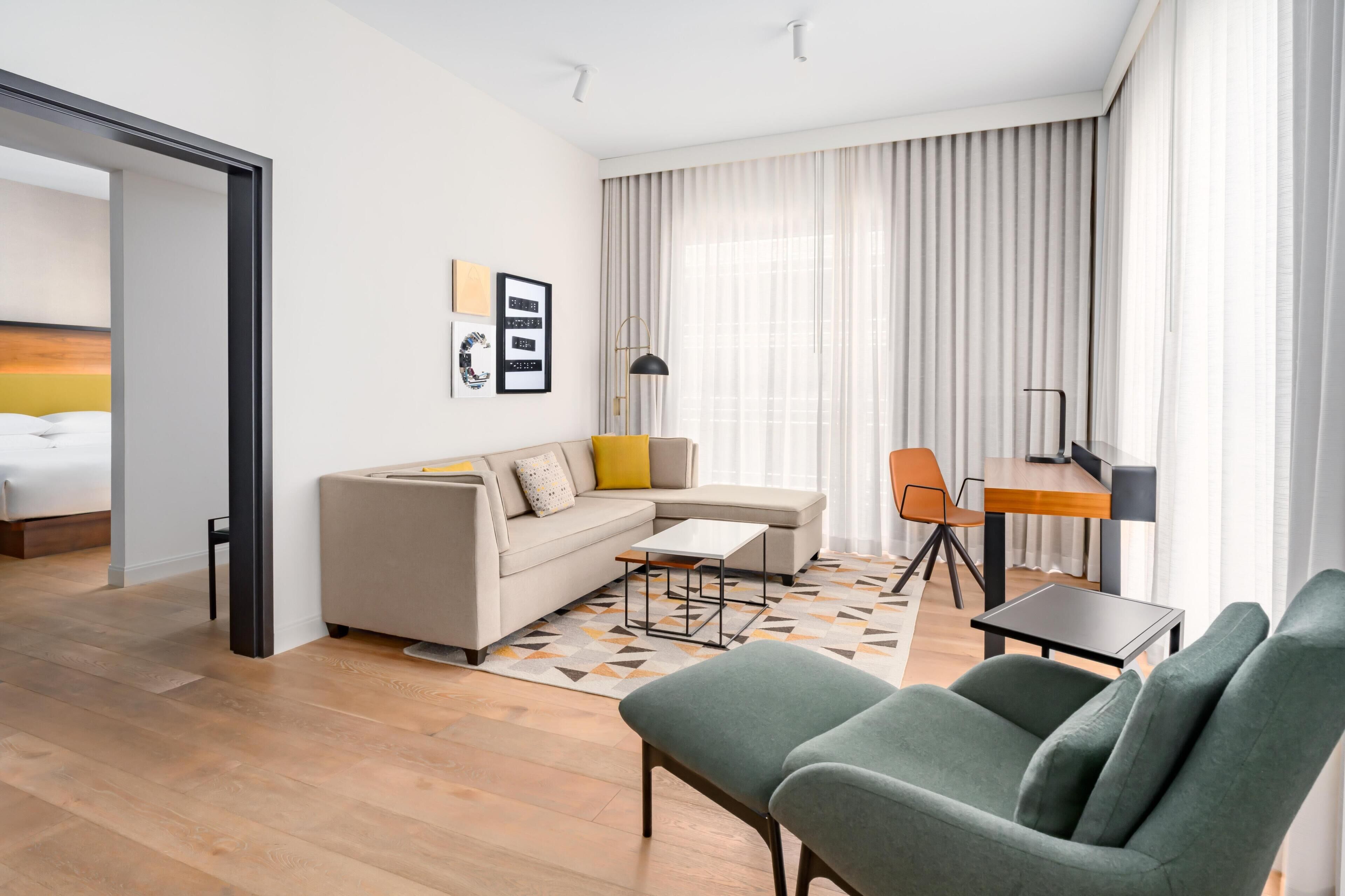 Uma sala de estar moderna com sofá, cadeiras, mesa de centro e área de jantar.