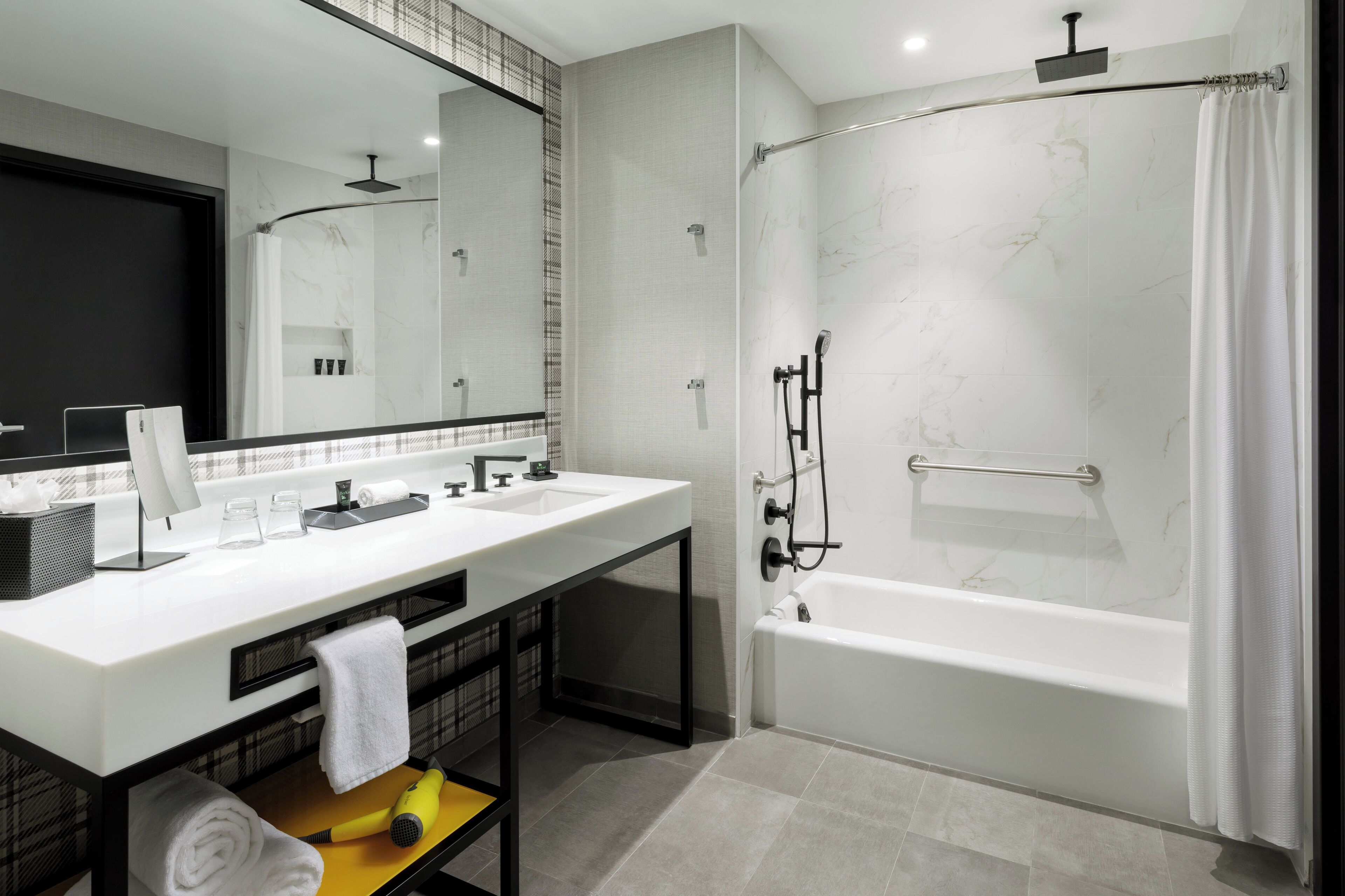 A modern bathroom with two sinks, a shower, and a large mirror.