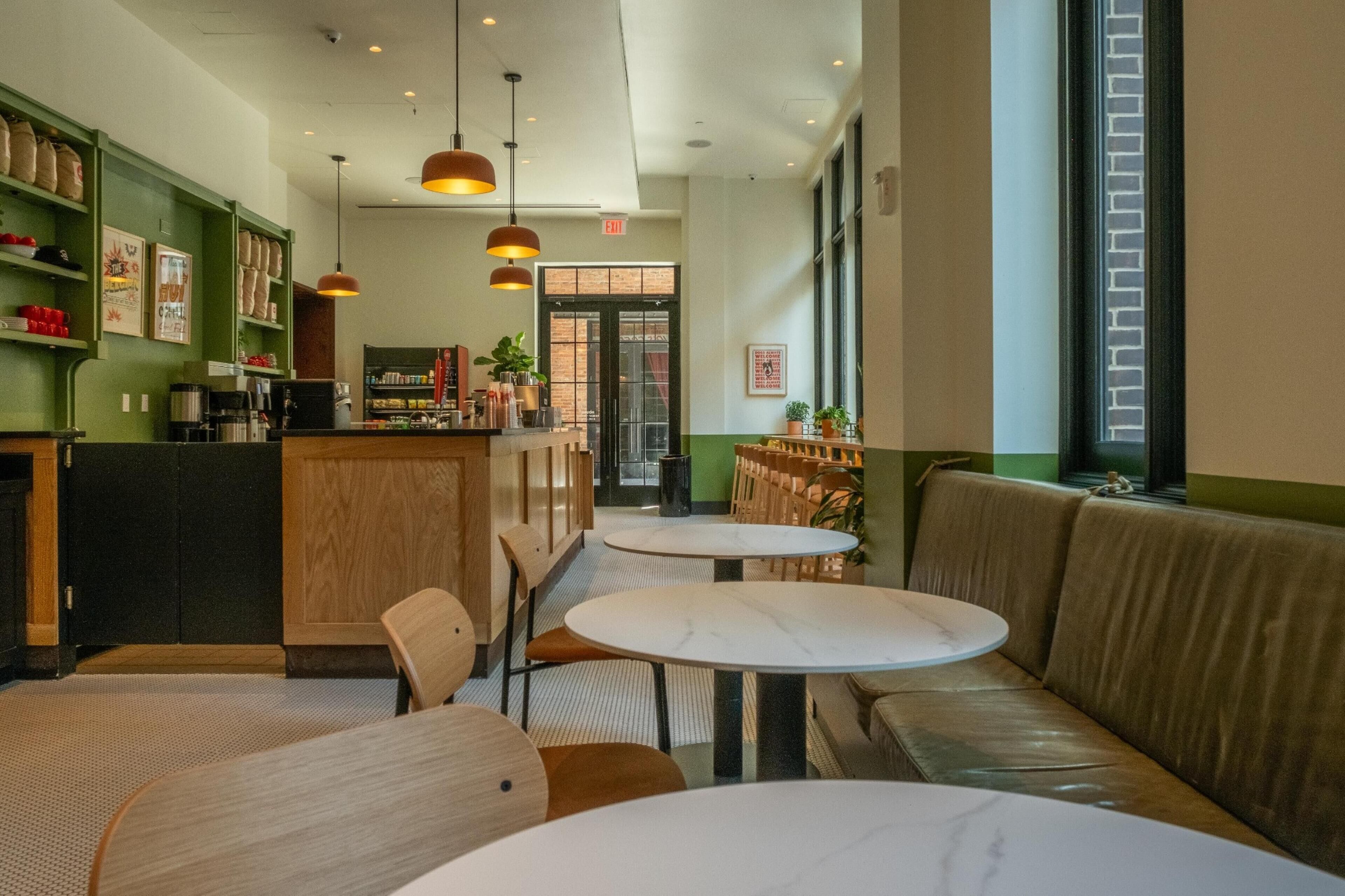 A cafe interior with a bar area, seating, and a view through a window.