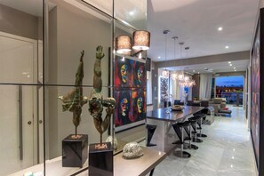 Une cuisine moderne dotée d’une cloison en verre, d’appareils électroménagers en acier inoxydable et d’un décor contemporain.