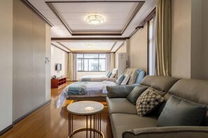 Una habitación de hotel moderna con un sofá, una mesita redonda, una cama con vistas y un televisor.
