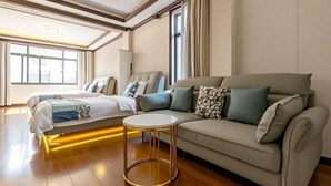 A modern hotel room with a bed, sofa, and round coffee table. - Zhouzhuang Yuesheng Hotel (Kunshan)