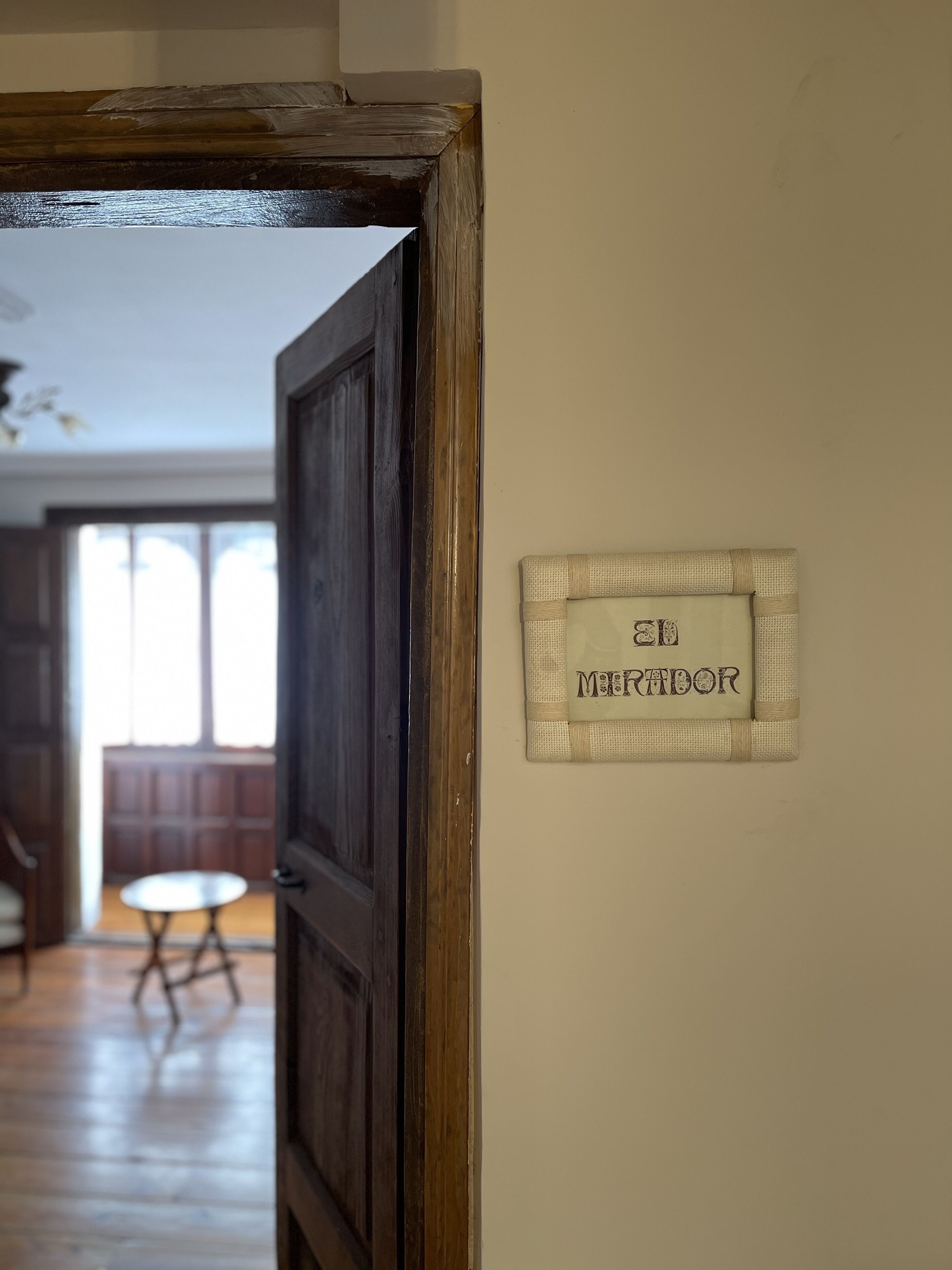 Marco de puerta de madera con un cartel en la pared que dice "EL MERADOR".