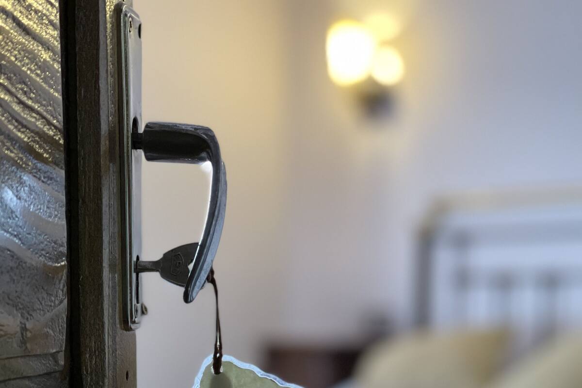 A wooden door with a keyhole and a keychain with the word "SLEEPING" attached.