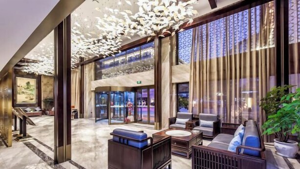A lobby with a seating area, large windows, and a decorative ceiling. - San Xia Feng Hotel (Yunyang County)