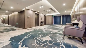 A hotel lobby with a patterned carpet, a reception desk, and seating area. - San Xia Feng Hotel (Yunyang County)