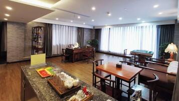 A hotel room with a dining area, a pool table, and a bar area.