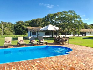 Una piscina al aire libre, sombrillas, tumbonas