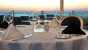 A table set for dining with a view of the sea at sunset. - Spectacular Boca Grande Waterfront Views of Gasparilla Sound; Boca Grande Club (Boca Grande)