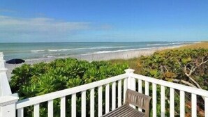 A beach view from a balcony with a white railing, a bench, and a view of the ocean. - Spectacular Boca Grande Waterfront Views of Gasparilla Sound; Boca Grande Club (Boca Grande)