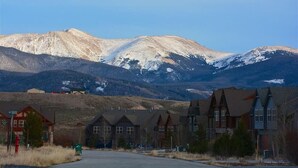 A mountain town with rustic buildings, a clear sky, and snow-capped peaks in the background. - 67 Fireweed | 4BR Hot Tub, Sleeps 13 (Tabernash)