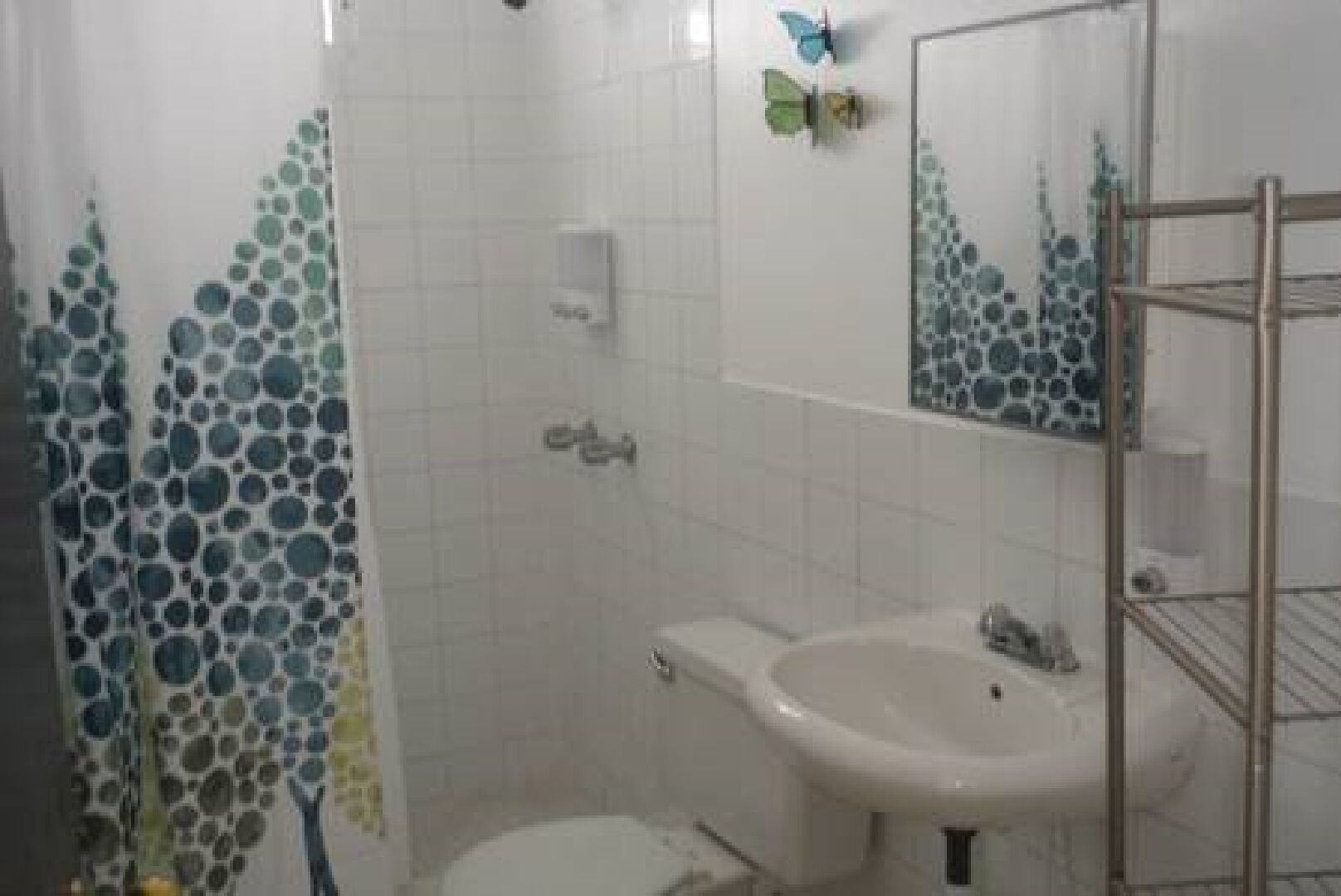 Une salle de bain comprenant des toilettes, un lavabo et un espace douche.