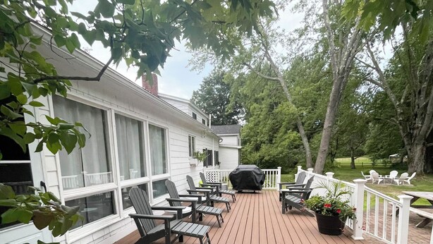A wooden deck with outdoor furniture, including chairs and tables, and a barbecue grill. - Maple View House, 3 fireplaces, sauna, game room, 4 living rooms, 4 TVs, grill (North Conway)